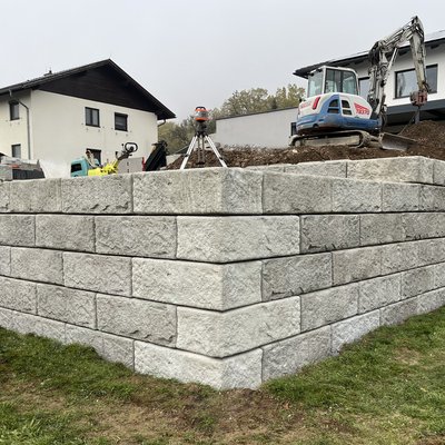 Robuste SW-Stützwand bildet die stabile Rückseite für den neu angelegten Garten mit Pool und Gerätehaus