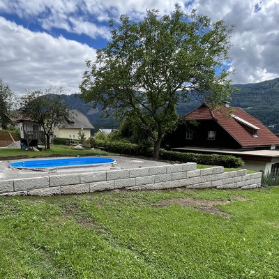 Terrassiertes Grundstück mit Pool und abgestufter Betonmauer in Weißenstein