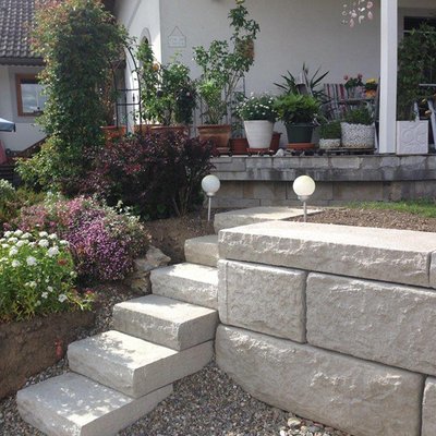 Helle Betonstufen führen zum privaten Badeplatz – perfekt integriert mit Natur und Terrasse