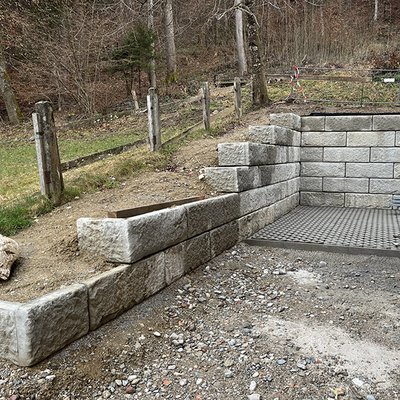 Kompakte Stützmauer in Natursteinoptik für sichere Böschung am Grundstücksrand