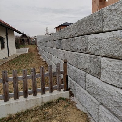 Hohe Hangmauer als stabile Grenze zwischen Neubau und Nachbargrundstück