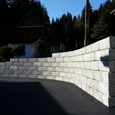 Die gebogene Hangbefestigung mit Natursteinoptik bringt Sicherheit und moderne Optik