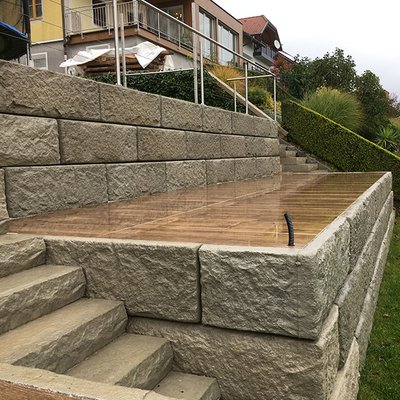 Die erhöhte Terrasse wird von einer stabilen Stützmauer sicher eingefasst