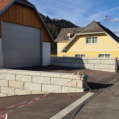 Betonmauer sichert die neue Einfahrt und gleicht den Höhenunterschied zum Hofgelände aus