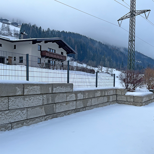 Stützwand mit integriertem Zaun als Gartenabgrenzung
