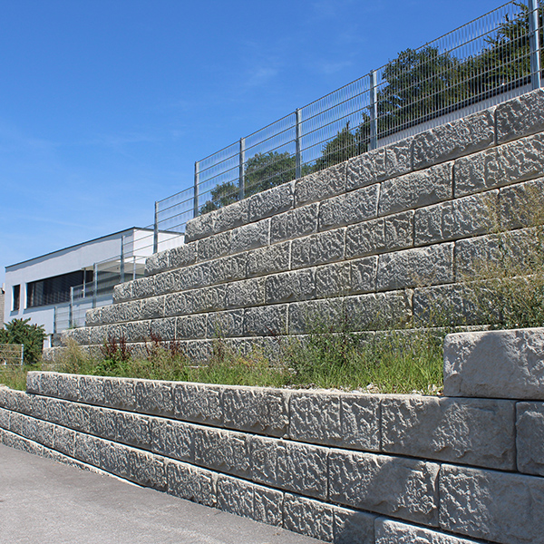 Mehrstufige Betonwand sichert steiles Gelände und schafft grüne Terrassenflächen